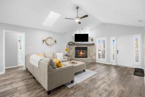 a living room with a couch and a fireplace at NEW POOL & Spa Coming May 2025 - NEW HOT TUB Available now- Dog friendly 4BR private home 6Min Walk to Beach in Myrtle Beach