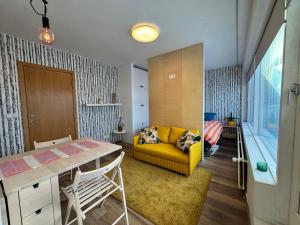 een woonkamer met een gele bank en een tafel bij Bright & Cozy Central Studio in Reykjavík