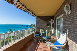 a balcony with chairs and a table and the ocean at Casa Mare Apartamento en primera línea de playa in Almuñécar