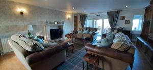 a living room with two couches and a fireplace at Marshill Farmhouse in Blackwood