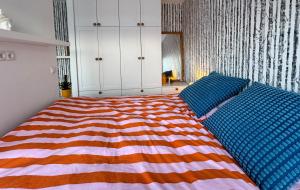 een slaapkamer met een bed met een kleurrijk gestreepte deken bij Bright & Cozy Central Studio in Reykjavík