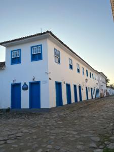a large white building with blue doors and windows at Casa Centro Historico in Paraty +22 photos