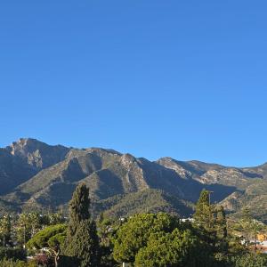 a mountain range with trees and mountains in the background at Marbella city center appartment walking distance beach and plaza de los naranjos in Marbella +34 photos