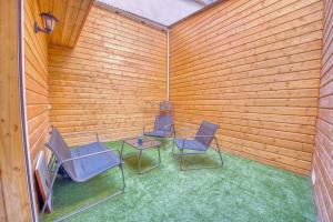 3 Stühle und ein Tisch in einem Zimmer mit Holzwänden in der Unterkunft Horizon Houzeau in Reims