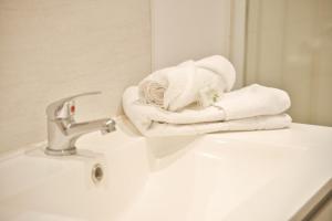 ein Badezimmer mit weißen Handtüchern auf einem Waschbecken in der Unterkunft Horizon Houzeau in Reims + 32 Fotos