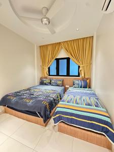 due letti in una camera da letto con finestra di NEWLY RENOVATED Comfy Beachfront View At Seri Bulan Port Díckson a Port Dickson