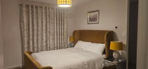 una camera da letto con un letto, una lampada e una finestra di Abi's World - 23 Kilmartin Grove Green, Hollystown, Dublin 15 a Dublino