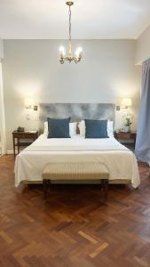 a bedroom with a large bed with a chandelier at Lafayette Hotel in Buenos Aires