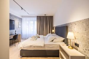 斯普利特Riviera Premier Suites的一间酒店房间，配有一张大床和一张书桌