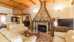 a living room with white furniture and a fireplace at Cortijo el Alcornocal by Ruralidays in Villanueva de la Concepción
