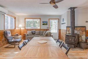 a living room with a wooden table and a wood stove at Mr. Gnomerson’s Hideaway | AC, EV, Pets in Packwood