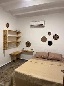 a bedroom with a bed and a fan on the wall at Ge boho house in Dahab