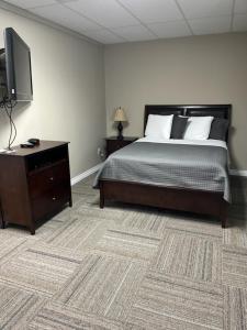 Un dormitorio con una cama y una cómoda con televisión. en Riverview Suites, en Clarenville 4 fotos más