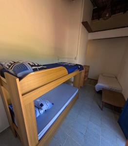 a room with two bunk beds and a chair at Guaecá Hostel - Cumuruxatiba in Cumuruxatiba