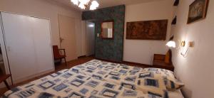 a bedroom with a bed with a comforter on it at Le Petit Bouleau in Saint-Pardoux-la-Rivière