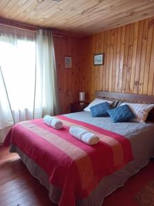 a bedroom with a bed with two pillows on it at Cabaña en Contao Carretera Austral Hualaihué in Contao