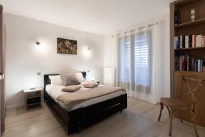 a bedroom with a bed and a book shelf at Appartement Victoria in Tournefeuille