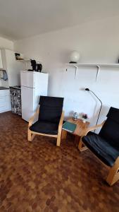 a room with two chairs and a table and a cat at Le Petit Bouleau in Saint-Pardoux-la-Rivière