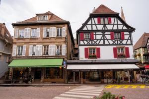 a group of buildings on a street with a crosswalk at Au Cocon de J in Obernai
