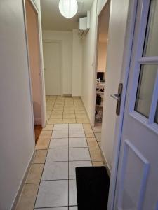 an empty hallway with a door and a tile floor at Bien proche de Aeroport St Exupéry Village de Marques et Lyon in Diémoz