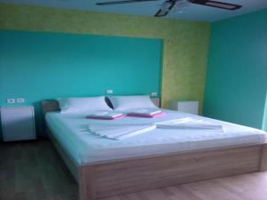 Un dormitorio con una cama grande con una pared verde. en Apartment in Greece near the Sea with Garden, en Rafina
