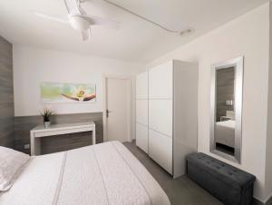 a white bedroom with a bed and a ceiling fan at Apartamento Martin in Tossa de Mar