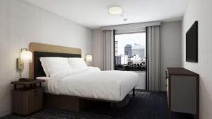 a bedroom with a white bed and a large window at Homewood Suites By Hilton Jackson in Jackson