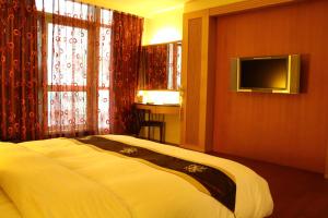 a bedroom with a bed and a flat screen tv at Constellation Coast B&B in Hualien City