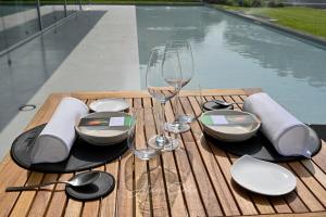 ein Holztisch mit Weingläsern und Tellern darauf in der Unterkunft Casa Format in Beinasco