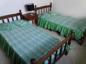 2 aparte bedden in een kamer met een nachtkastje bij Chacara Casa de Campo in Tietê +10 foto's