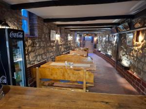a restaurant with a row of tables in a room at Krčma i prenočište Fra Luka Požega in Požega