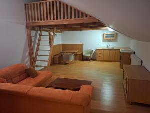 a living room with a couch and a kitchen and a staircase at Krčma i prenočište Fra Luka Požega in Požega