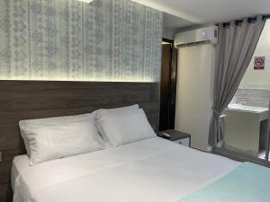 a bedroom with a white bed and a window at Luxury liv Gran limonar in Cali
