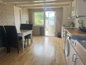 a kitchen with a table with chairs and a table at Fiskesenter Birkeland Guesthouse in Vestnes