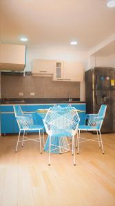 eine Küche mit 3 Stühlen, einem Tisch und einem Kühlschrank in der Unterkunft Cabaña Mary Mar en Isla in Cartagena in Isla de Tierra Bomba