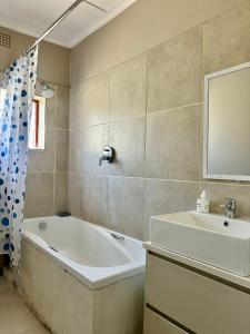 un baño con bañera y lavabo en One Bedroom House, en Goodwood