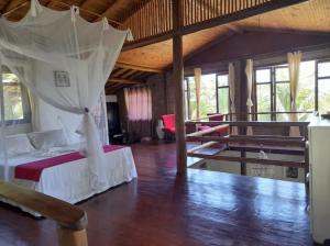 a bedroom with a bed with a mosquito net at Casa Beija Flor ILHA DE BOIPEBA in Ilha de Boipeba