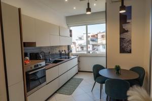 a kitchen with white cabinets and a table and a window at Cerasè Apartment in center-Sorrento Coast in Vico Equense