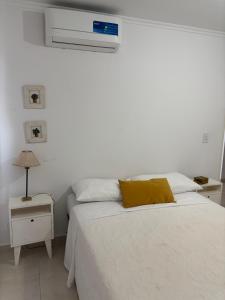 a bedroom with a white bed with a yellow pillow at Alba II - Departamento 2 ambientes in Posadas