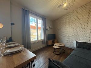 una stanza con un tavolo, un letto e una finestra di Le petit Lyautey - Retro-chic atmosphere a Vichy