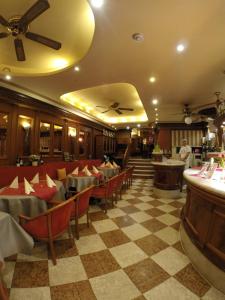 a restaurant with red chairs and a checkered floor at Hotel am Markt in Saarburg