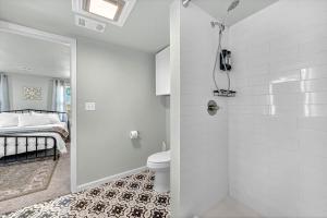 a bathroom with a shower with a toilet and a bed at University Place, family stay, practically on JBU campus in Siloam Springs +30 photos