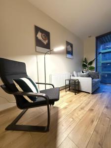 una sala de estar con una silla y un sofá en 2 bedroom Titanic Apartment - 1 night stays!, en Belfast