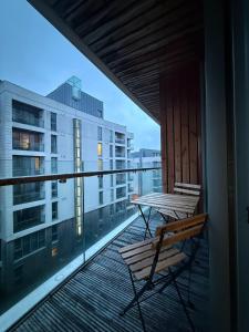 un balcón con un banco y una mesa en un edificio en 2 bedroom Titanic Apartment - 1 night stays!, en Belfast