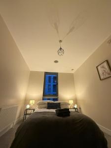 un dormitorio con una cama y una ventana en 2 bedroom Titanic Apartment - 1 night stays!, en Belfast