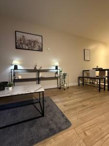 una sala de estar con dos camas y una mesa en 2 bedroom Titanic Apartment - 1 night stays!, en Belfast