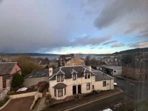 a large white house on the side of a street at The Bay View Apartment in Gourock
