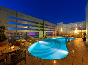 a large swimming pool in a hotel at night at Al Manzel Hotel Apartments in Abu Dhabi