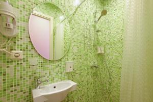 a green tiled bathroom with a shower and a sink at Amore in Saint Petersburg
