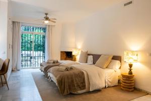 a bedroom with three beds and a fireplace at La Pinta Golf Villa Sotogrande in Sotogrande